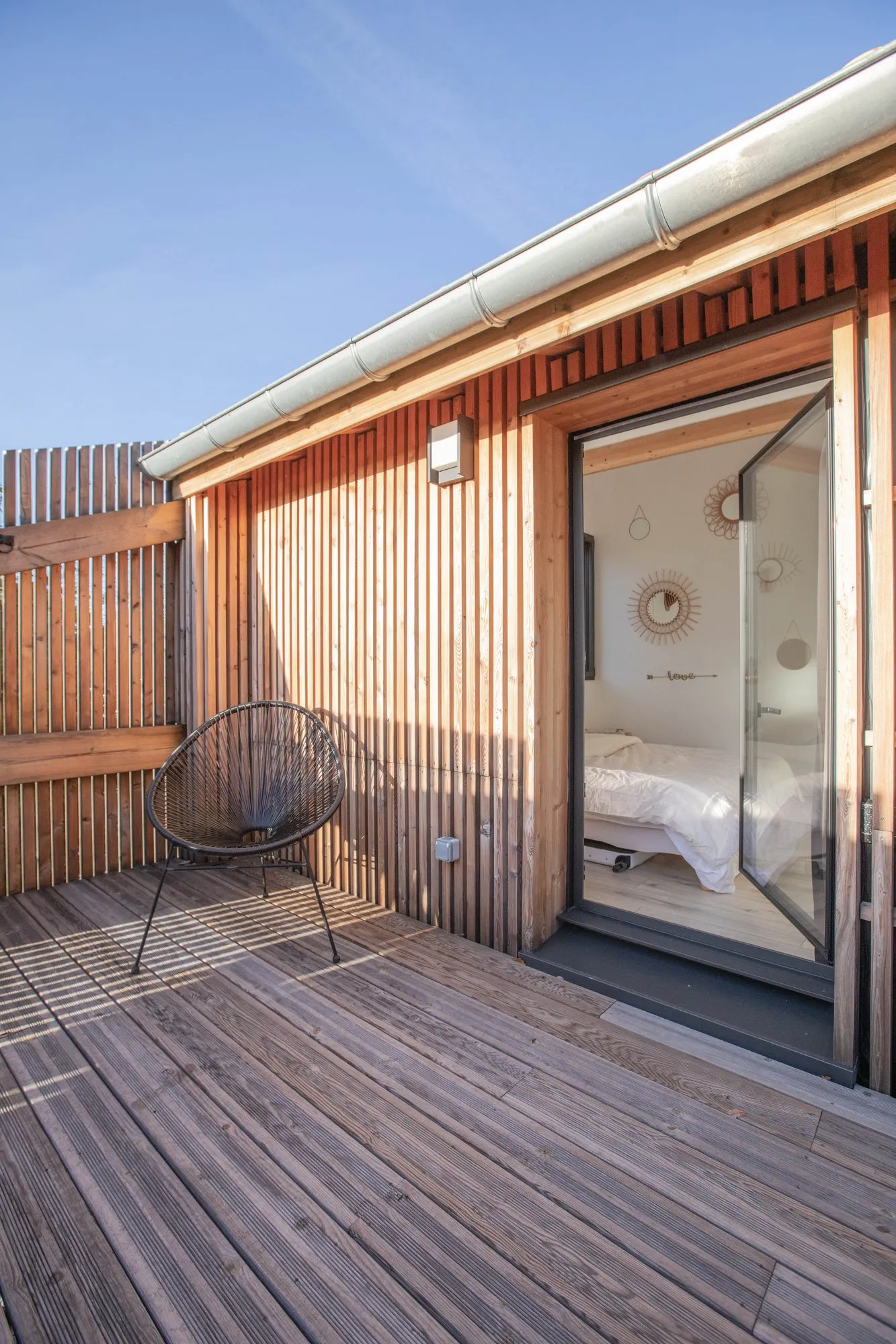 Le bardage mélèze et la porte-fenêtre d’une chambre, côté terrasse