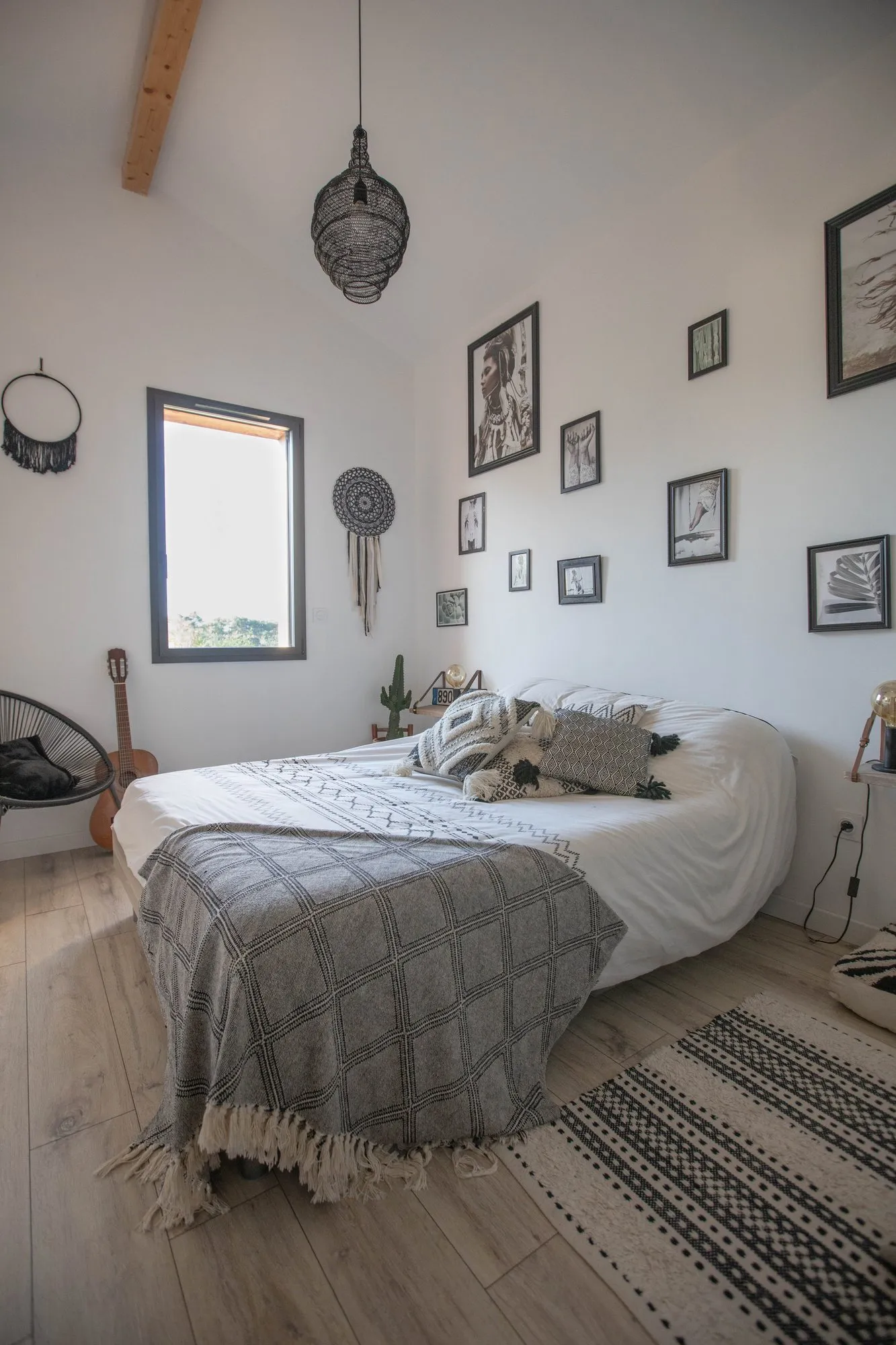 Une chambre sous rampant, murs blancs et poutres de bois