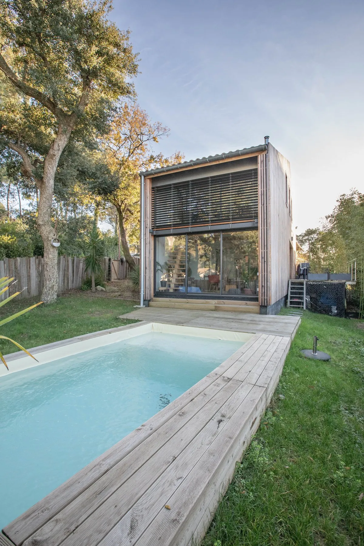 La maison livrée à Tarnos : un volume en bardage mélèze, une grande baie vitrée et la piscine bordée de bois