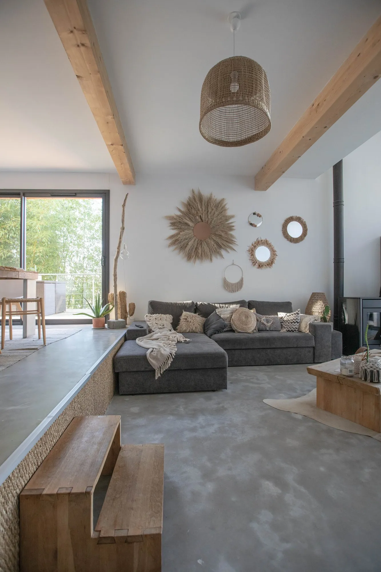Le salon, avec son canapé gris et sa charpente apparente